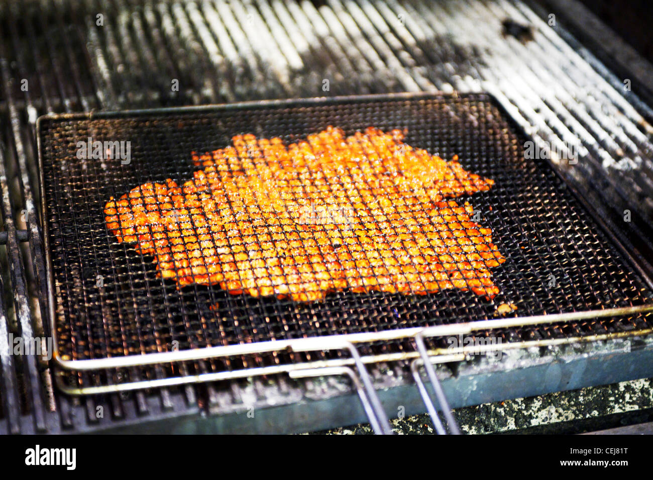 A chef cooking at the barbecue grill at a Korean restaurant. Stock Photo