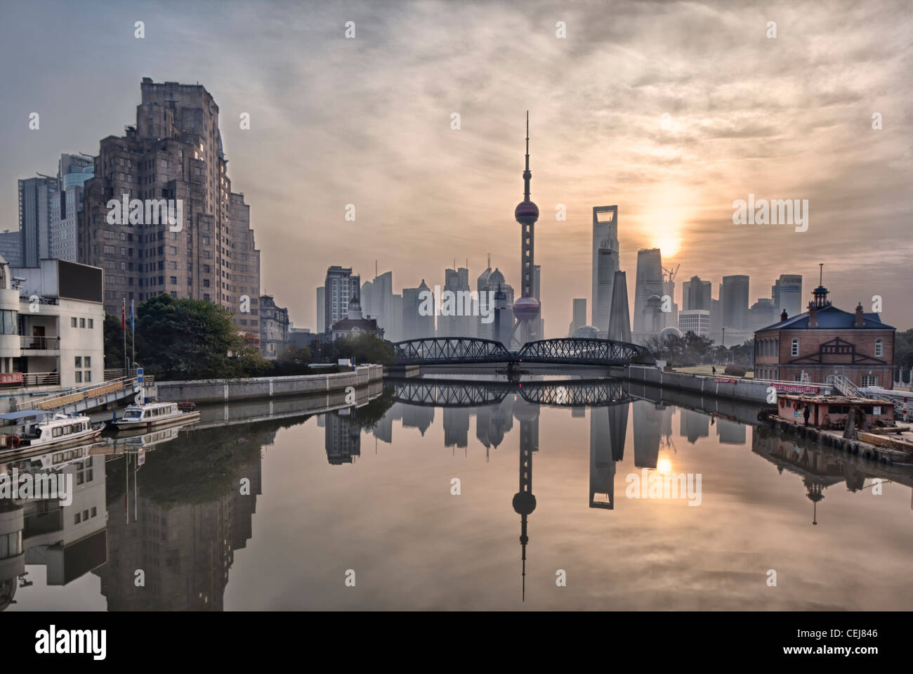 Morning Sunrise at the Suzhou river mouth, Shanghai, China. With Pudong skyline reflected in the water. Stock Photo