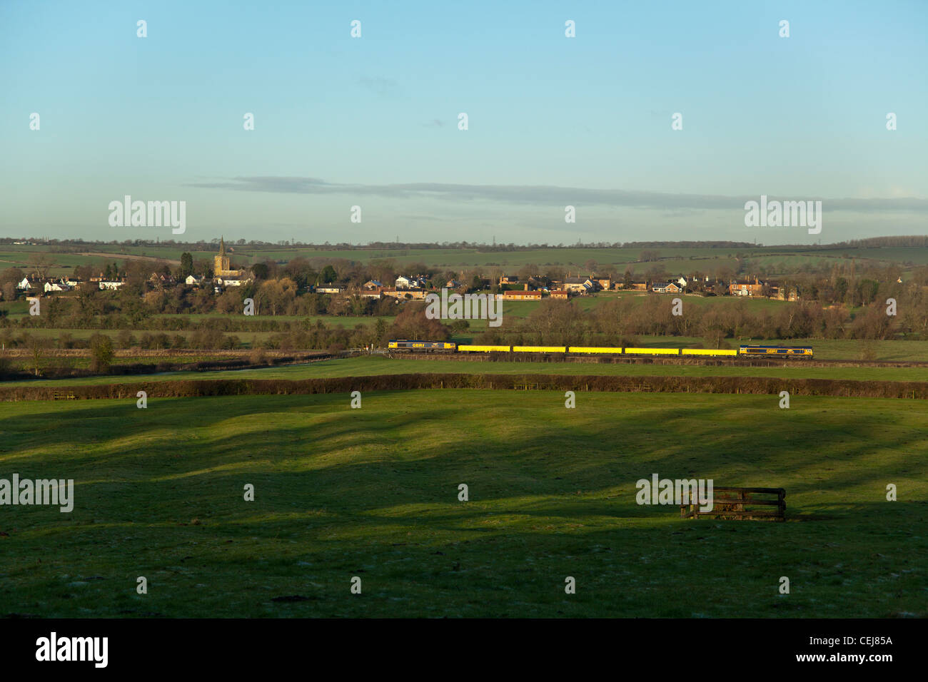 66736 tnt 66717 with 5 jna wagons pass between Rotherby and Hoby (background) villages 6H66 08.28 Peterborough - Derby Stock Photo