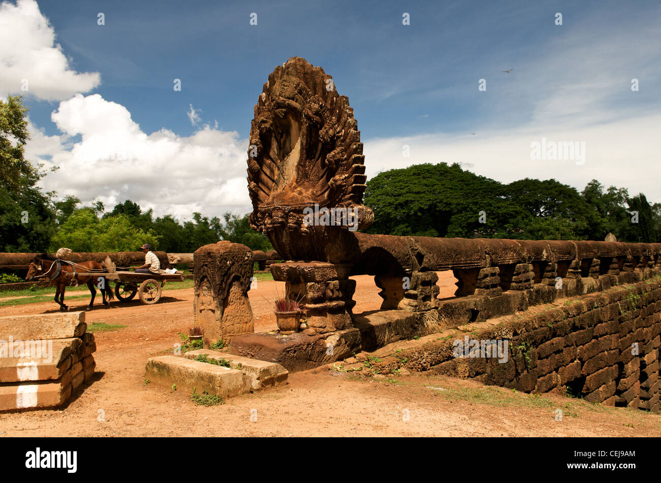 a horse cart crosses The Kampong Kdei bridge which spans the Chikreng River & was built during the Ancient Khmer Empire, Siem Reap Province, Cambodia. Stock Photo