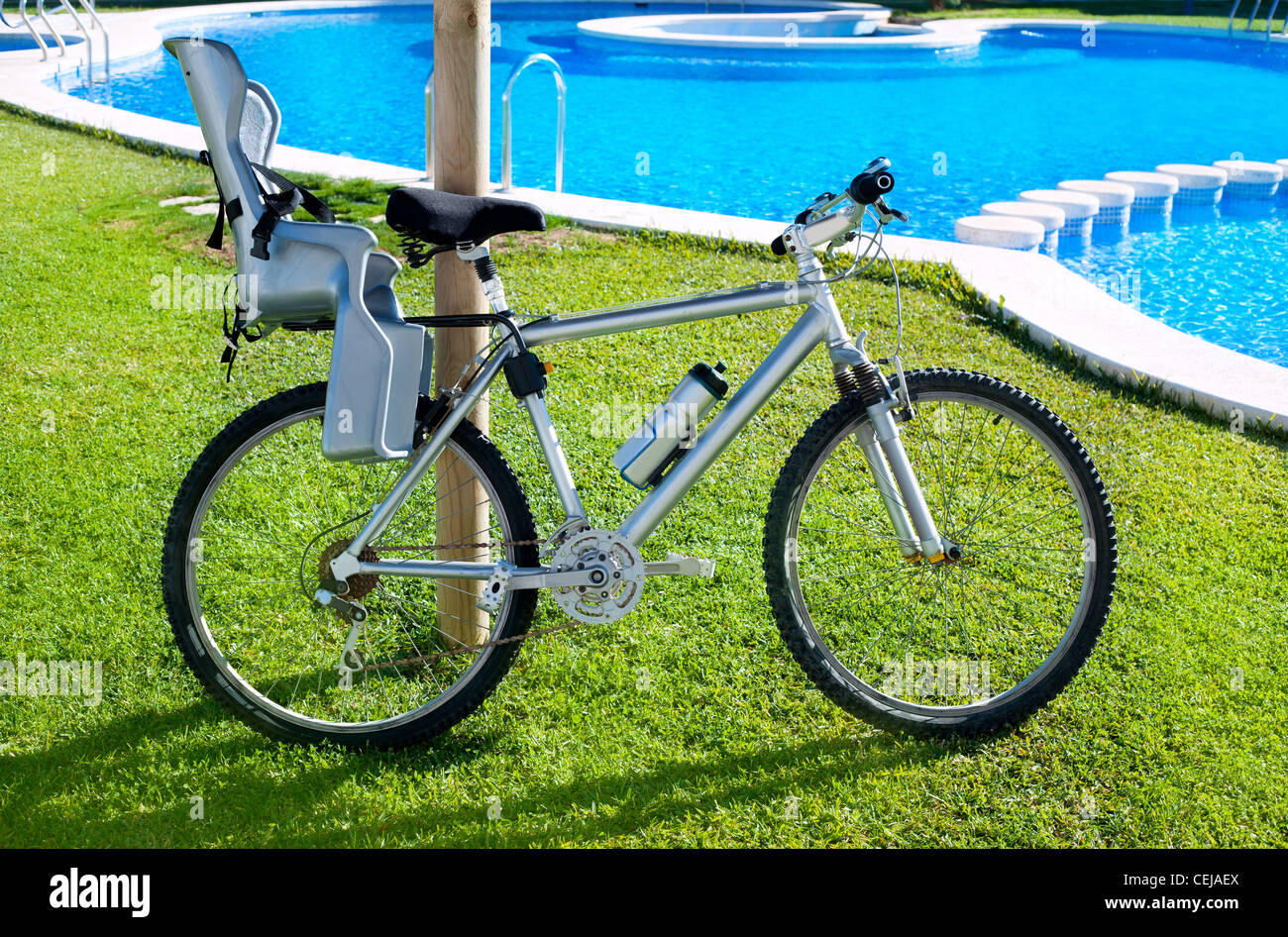 bicycle with baby seat in grass pool outdoor on summer vacation Stock Photo Alamy
