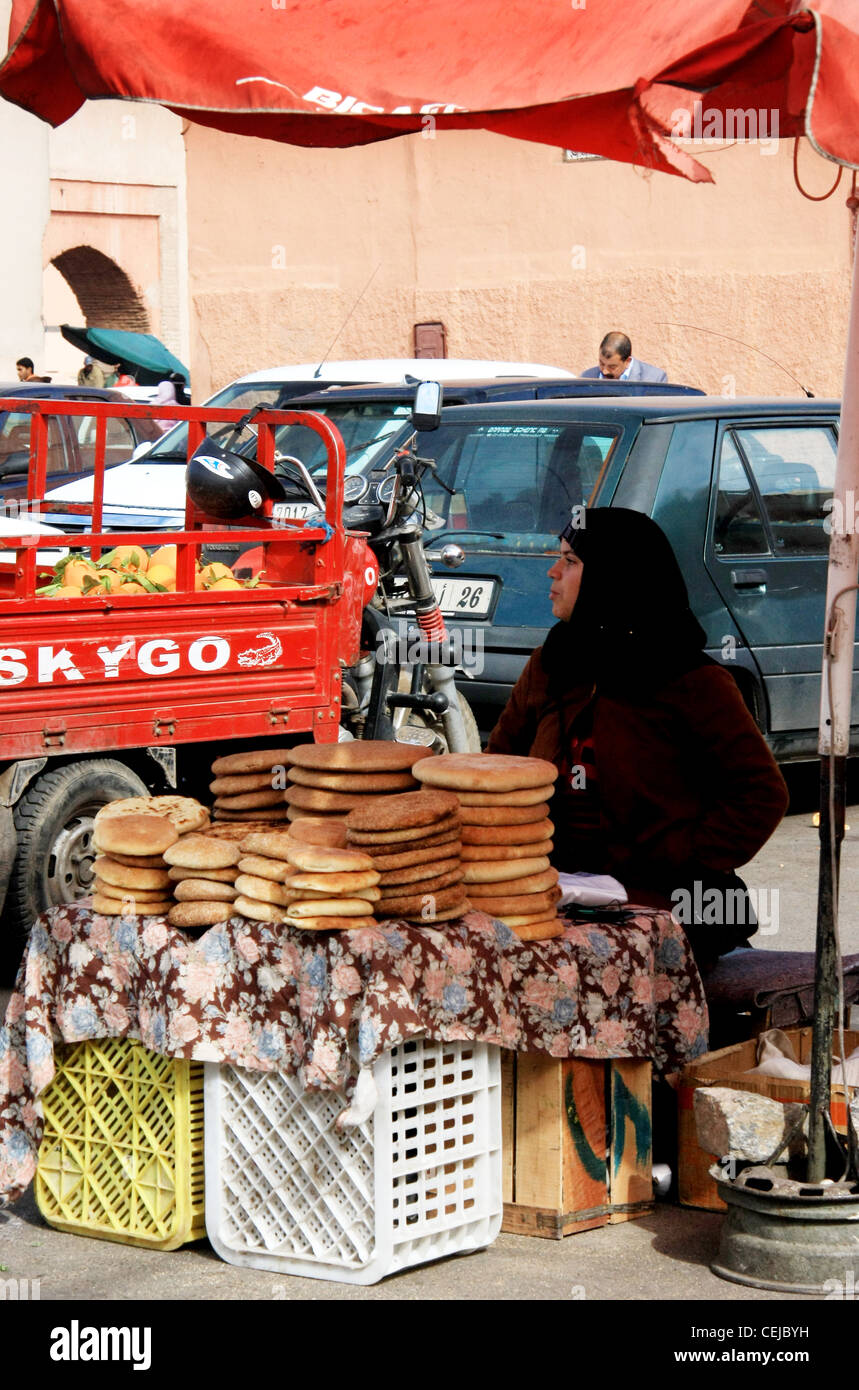 Moroccan woman sellling bread in her stall in Marrakech Medina market Stock Photo