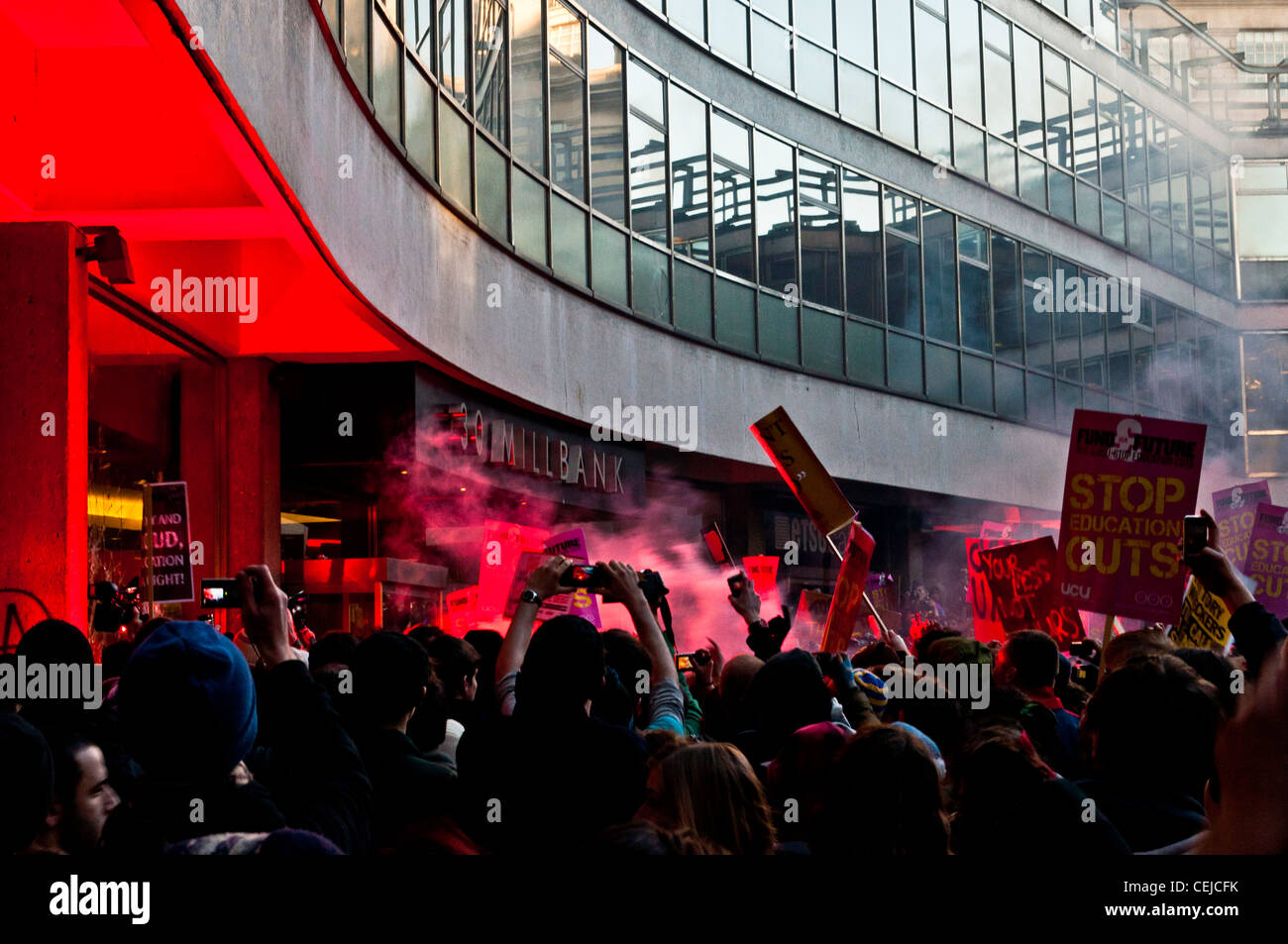 Student protesters ignite a red flare outside 30 Millbank, London, during NUS protest against tuition fee rises on Nov 10 2010. Stock Photo