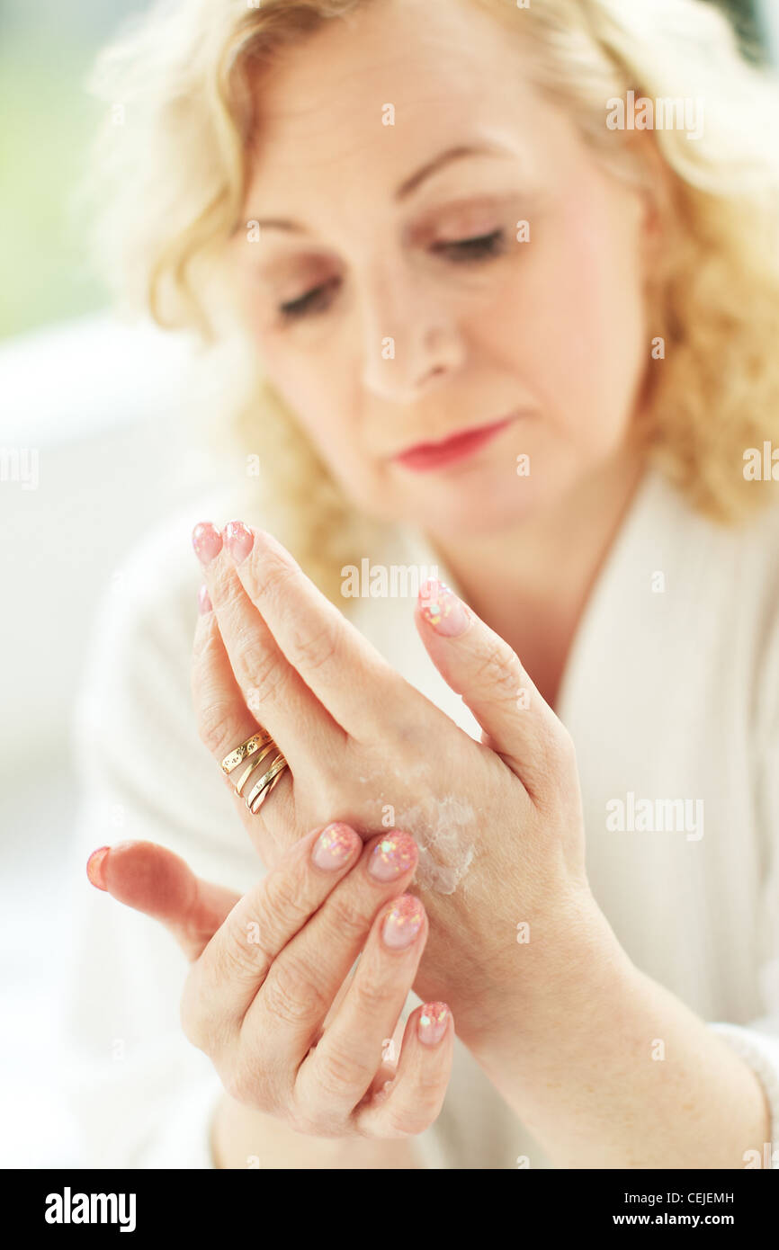 Woman applying hand cream Stock Photo
