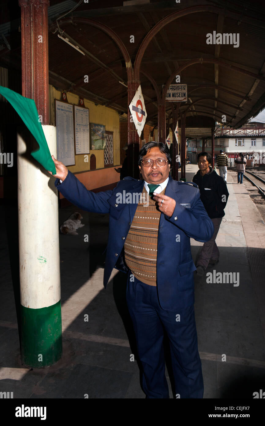 India, West Bengal, Ghoom Station Darjeeling Mountain Railway Station Master Mr Das waving off train Stock Photo