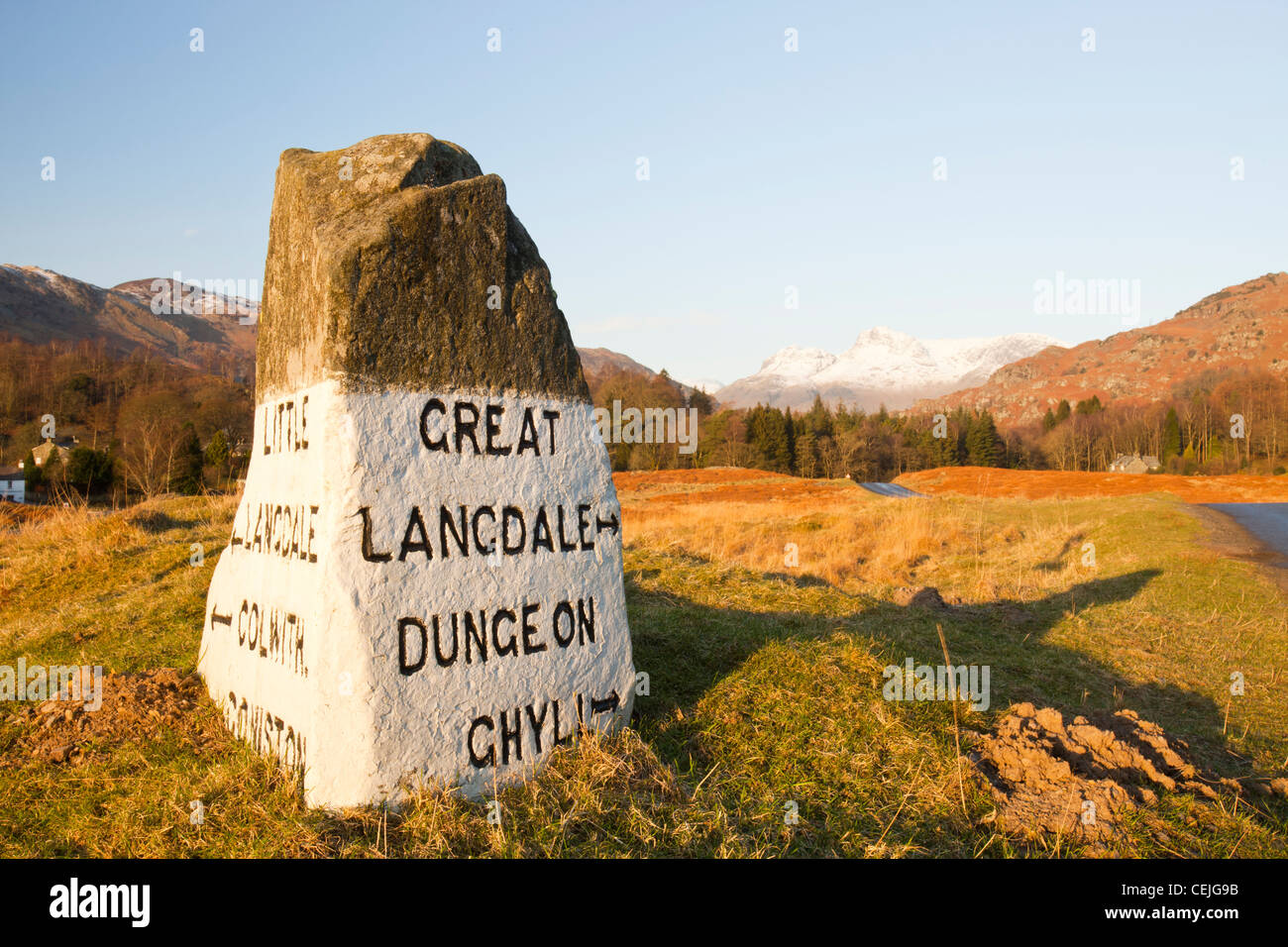 An old stone road sign in the Langdale valley at Elter water in the Lake District, UK, looking towards the Langdale Pikes. Stock Photo