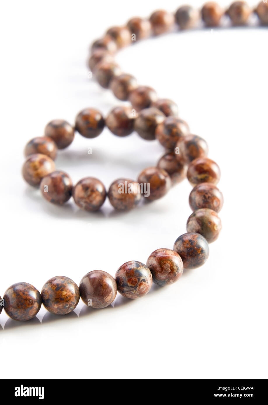 Leopard skin jasper gemstone beads on a white reflective background. Stock Photo