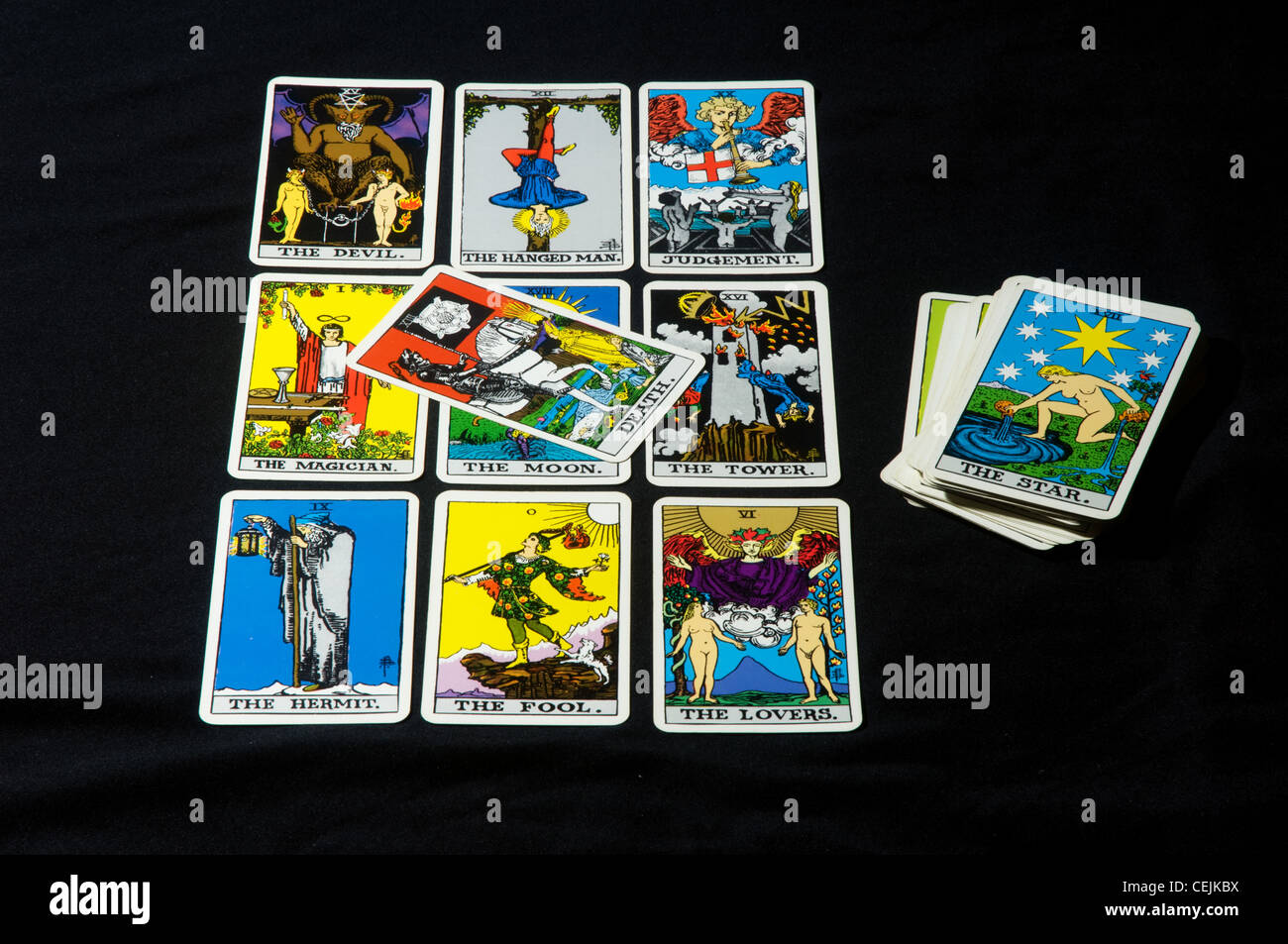 Tarot cards layed out in a square with the Death card in the middle and a pack of cards on the side with the Star card on top Stock Photo