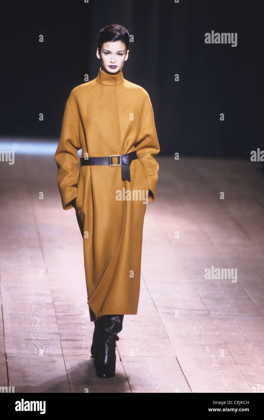 Yves Saint Laurent Autumn Winter Oversize long brown coat with black  leather belt, and black slouchy knee length boots Stock Photo - Alamy