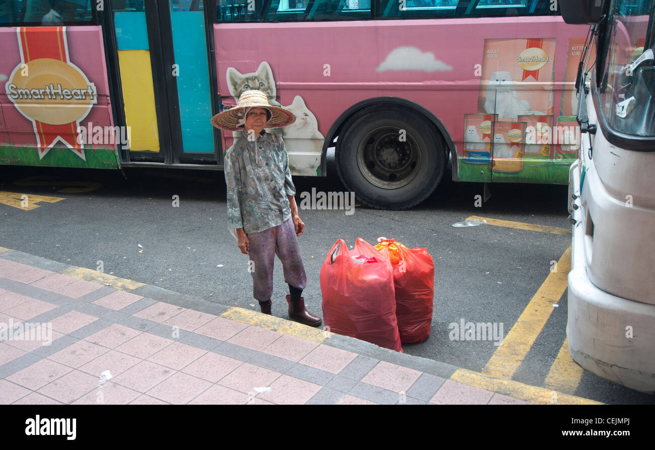 Old woman waiting for bus in Kuala Lumpur, Malaysia Stock Photo