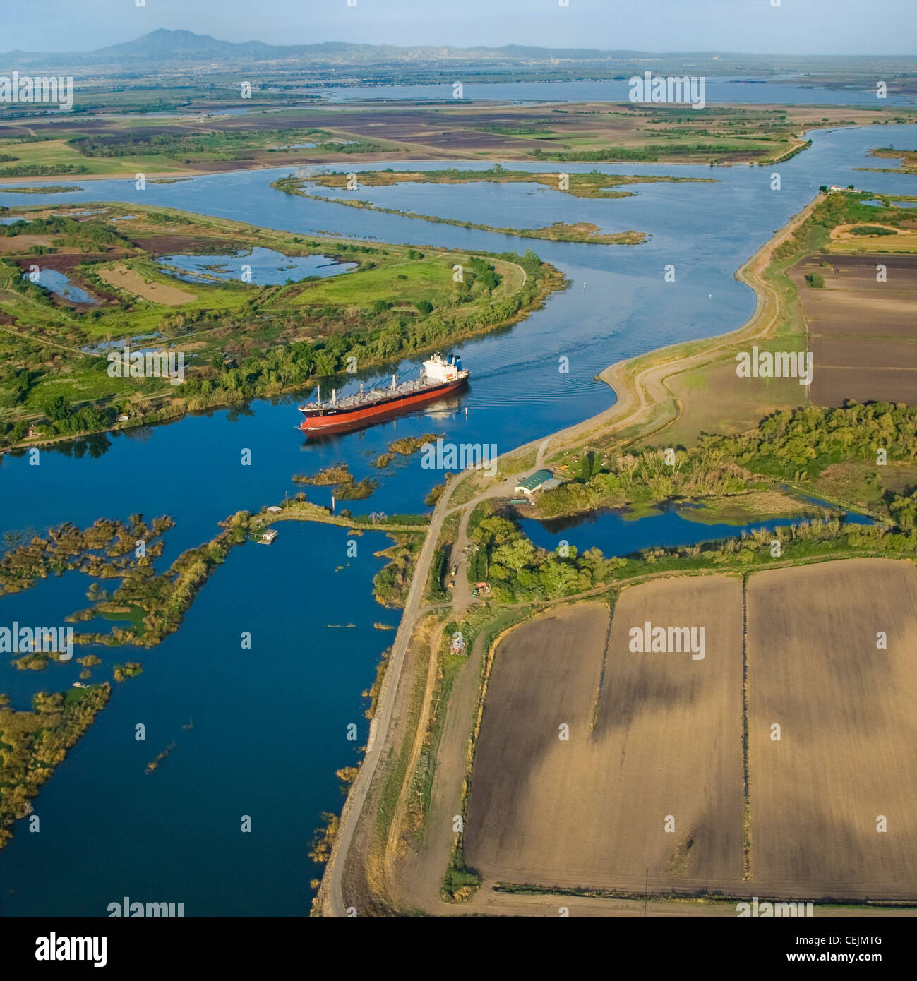 Aerial view of an ocean going grain ship transiting the deep water channel in the Sacramento-San Joaquin River Delta /California Stock Photo
