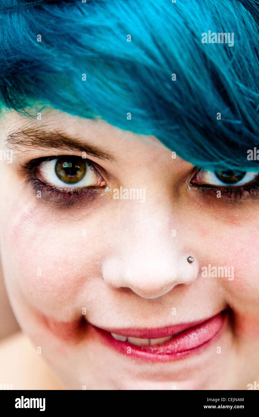 Portrait of a young woman looking insane like The Joker with turquoise hair Stock Photo