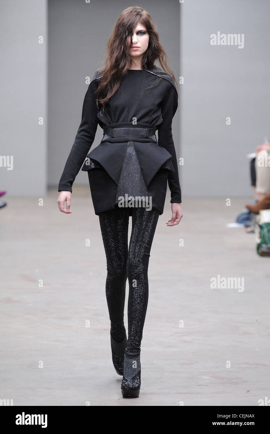 Black dress with long sleeves, geometrical ruffles, black tights and grey  platform ankle boots Stock Photo - Alamy