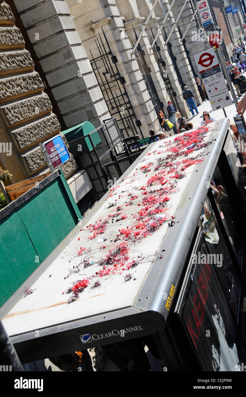 View from above looking down at tour bus stop & shelter roof littered with used free issue headphones discarded from top deck of tour bus London UK Stock Photo