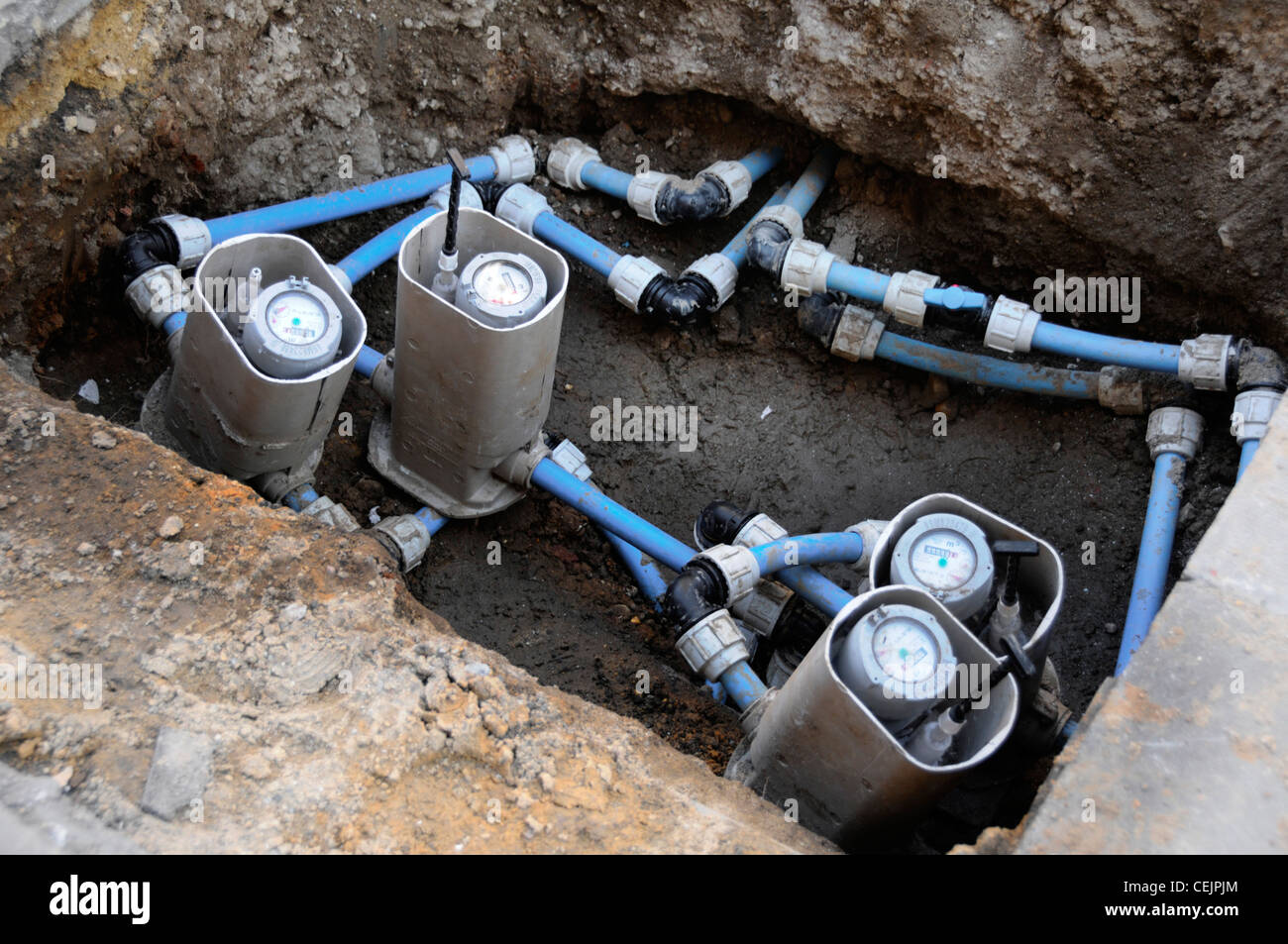 Water meter renewal in pavement pit part of water utilities infrastructure replacement of old iron pipe with plastic pipes to street water supply UK Stock Photo