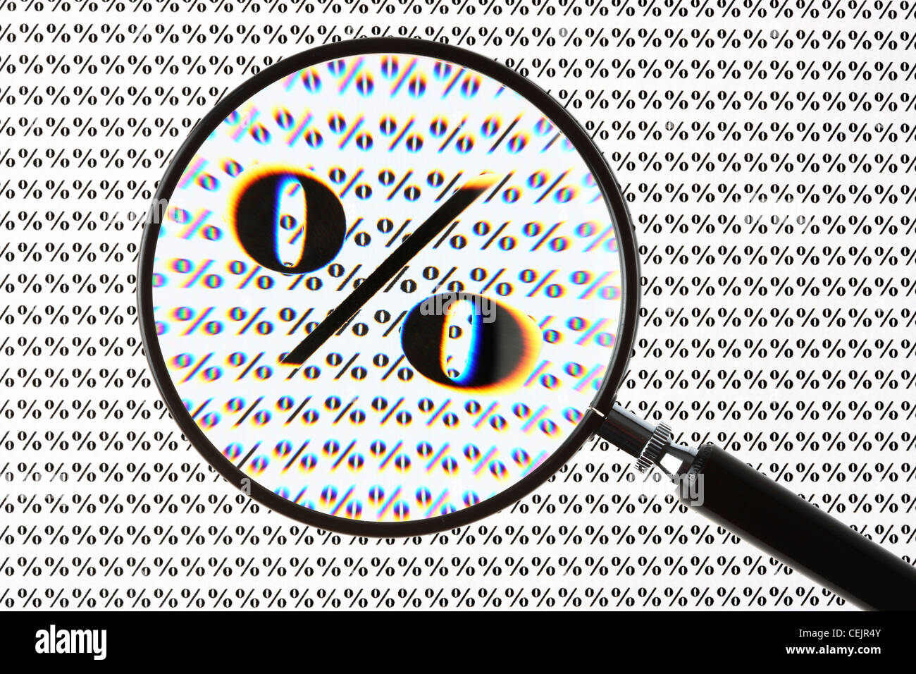 Magnifying glass highlighting a percent symbol. Symbol image. Stock Photo