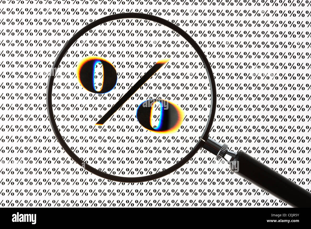 Magnifying glass highlighting a percent symbol. Symbol image. Stock Photo