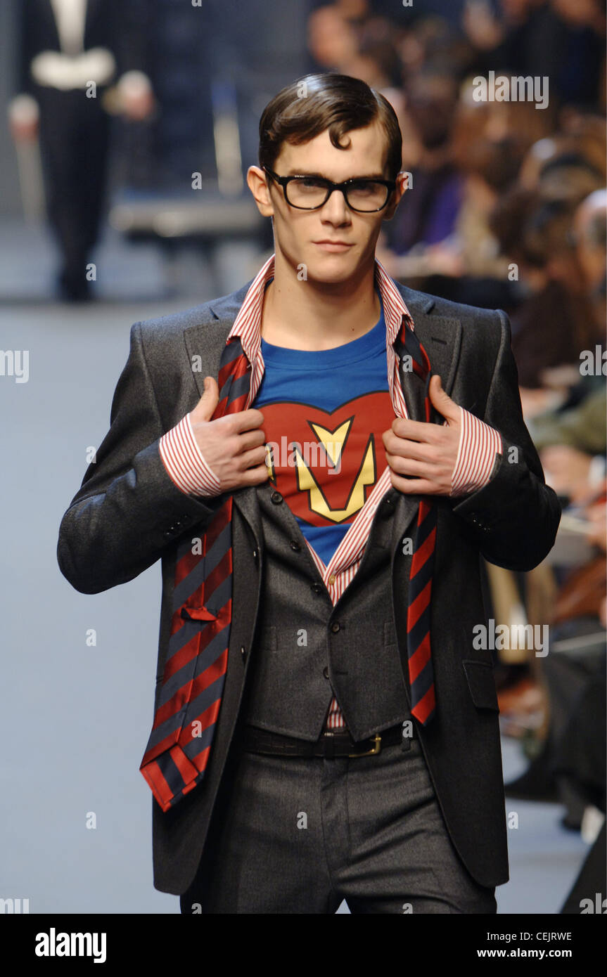 Moschino Menswear Milan A W Superman motif: Brunetted male hair and glasses indicative of Clark Kent, wearing a grey fitted Stock Photo