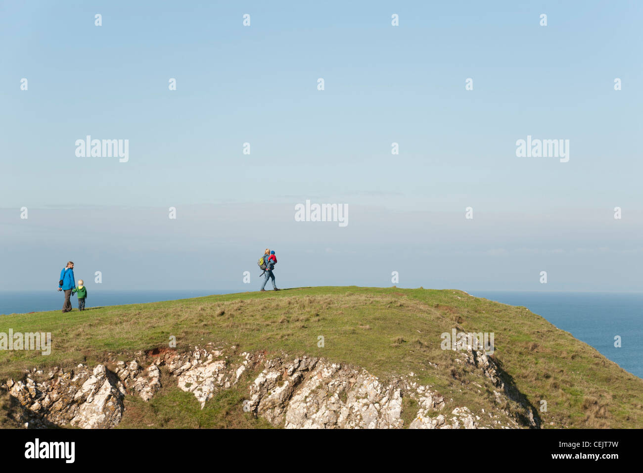 A family on a cliff top enjoying the view, Rhossili Bay, Gower Peninsula, South Wales Stock Photo