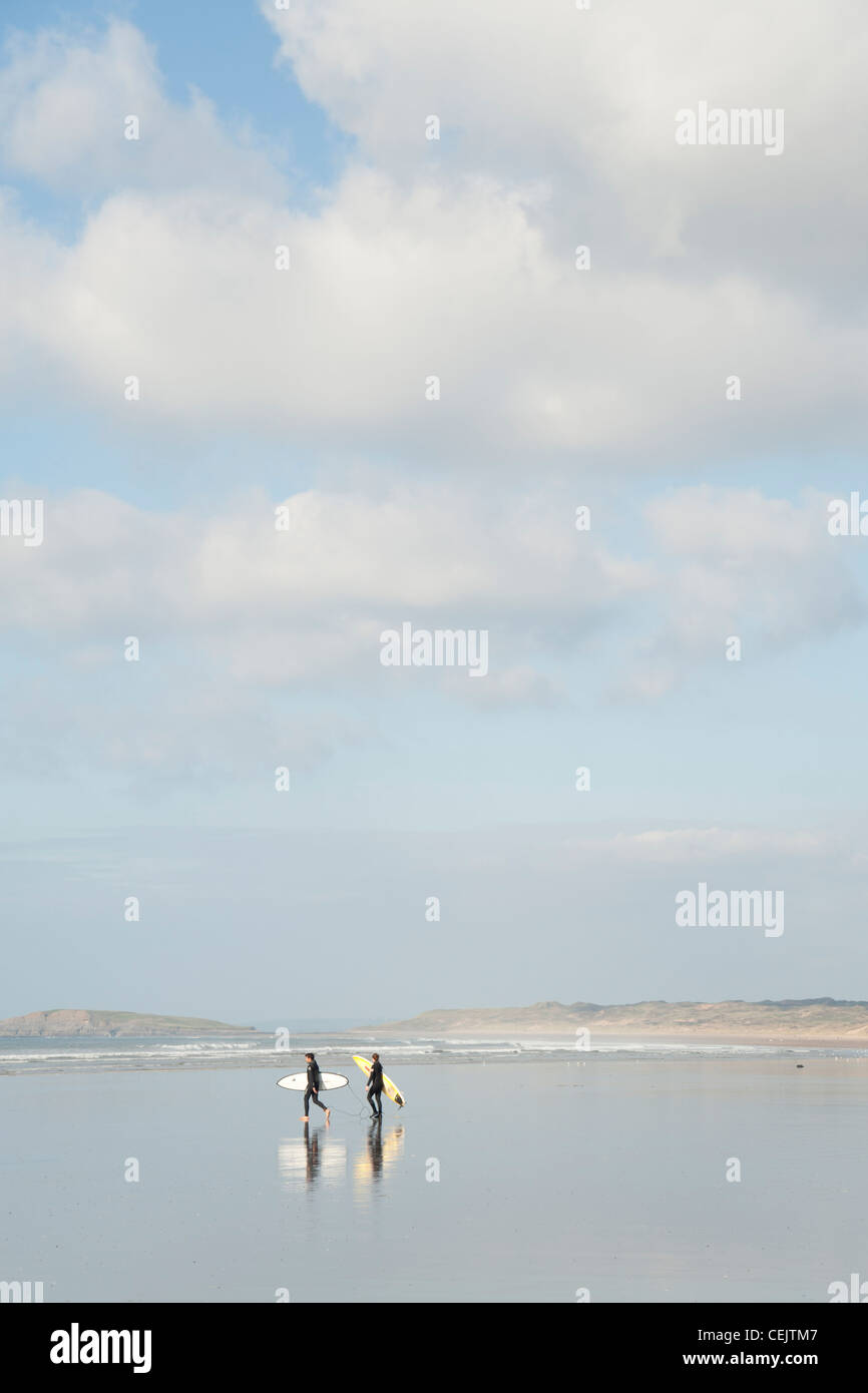 Surfers walking towards the sea, Rhossili Bay, Gower Peninsula, South Wales Stock Photo