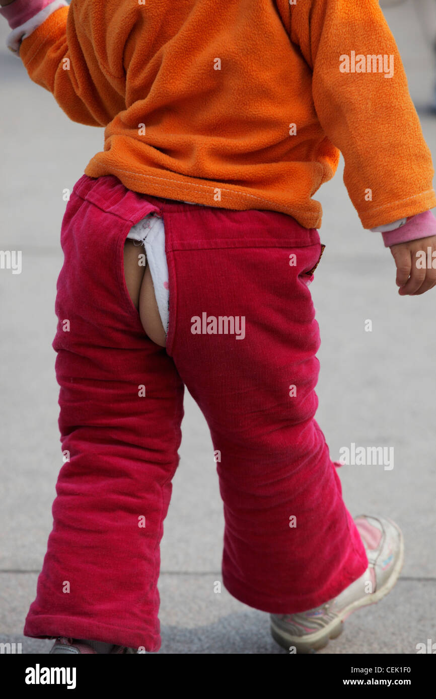 Young girl with bum exposed through split in pants Stock Photo - Alamy