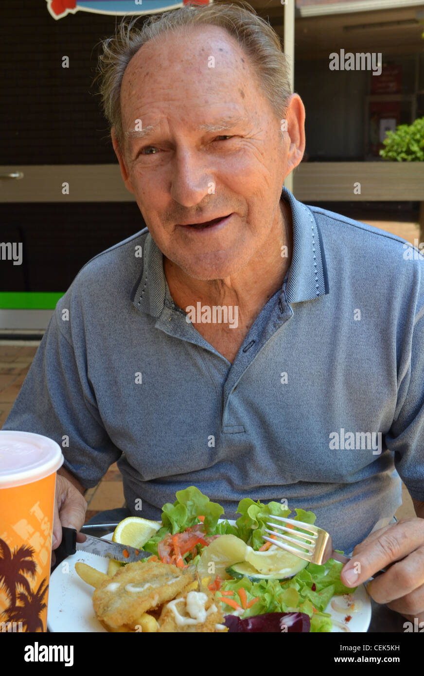 old man eating lunch at an outdoor restaurant in Queensland, Australia