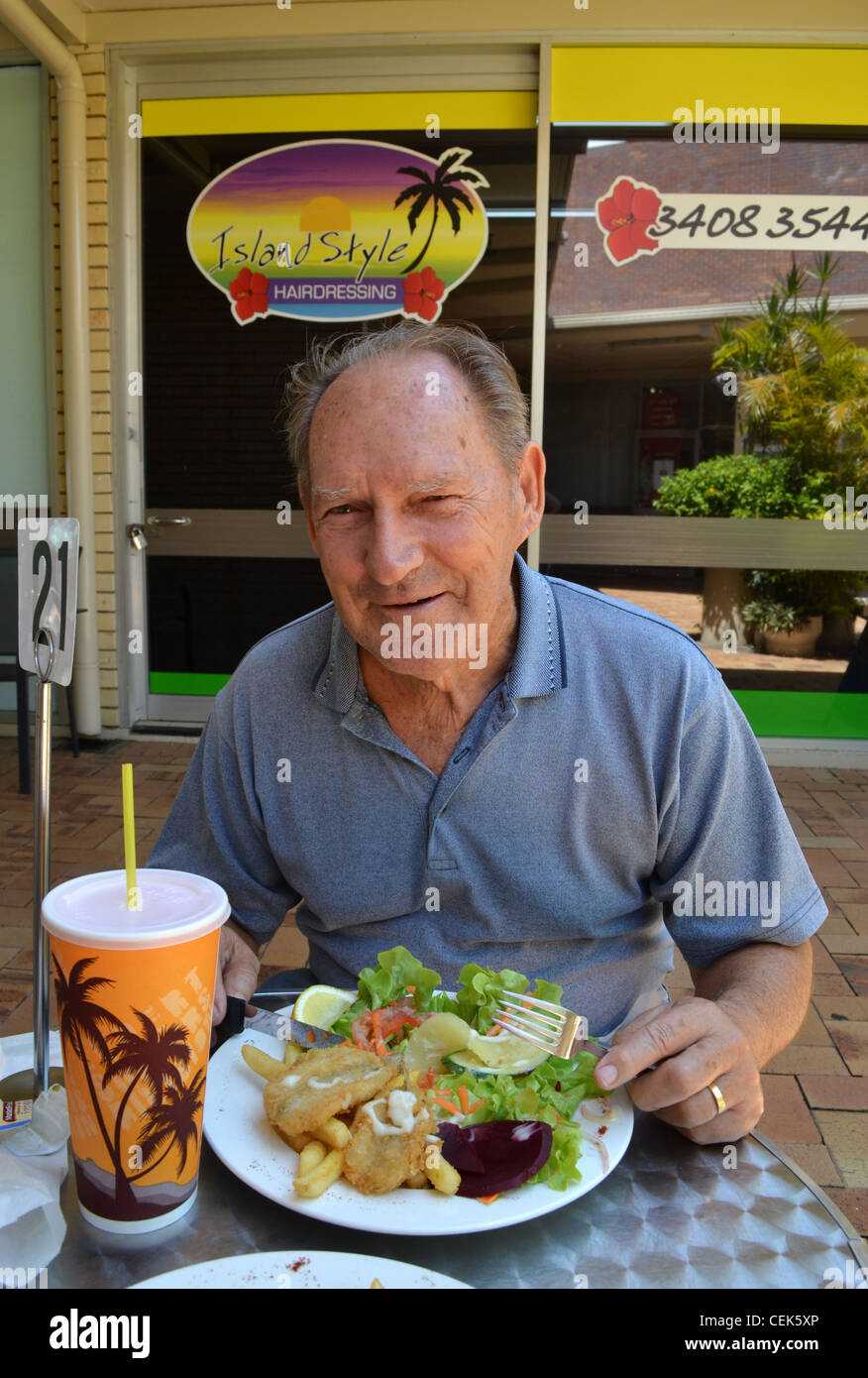 old man eating lunch at an outdoor restaurant in Queensland, Australia