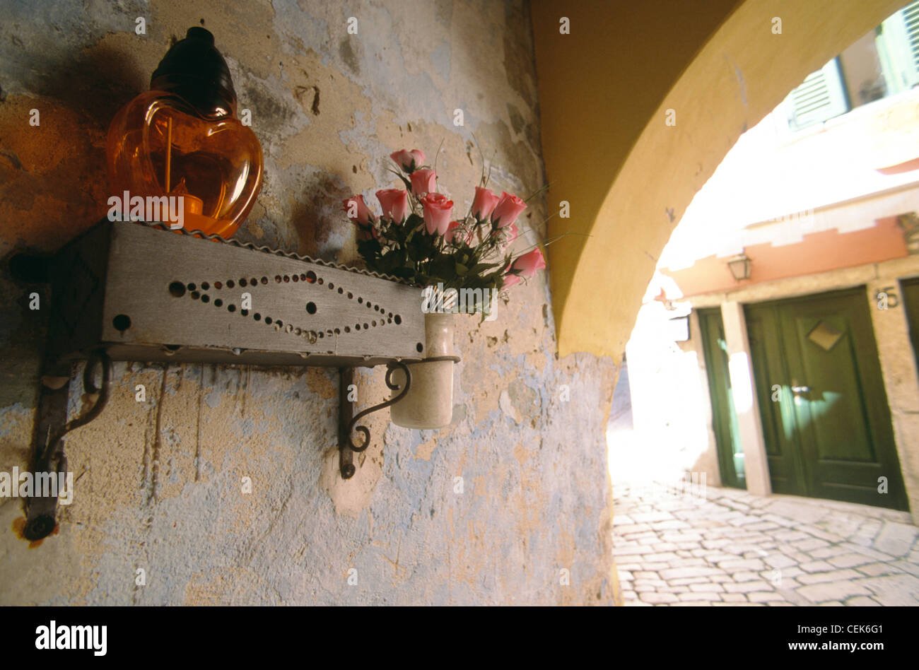 Candlelight and flowers of a public altar fixed at a wall in Rovinj, Istria, Croatia Stock Photo