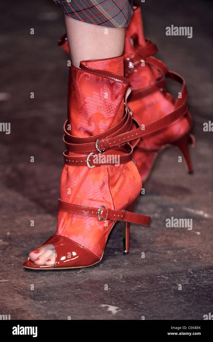 Vivienne Westwood London Ready to Wear Autumn Winter Detail image of model  wearing red peep toe ankle boots multiple straps Stock Photo - Alamy