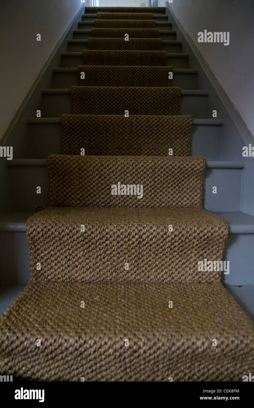 A rustic staircase with a sisal runner carpet in an oldfashioned cottage style Stock Photo Alamy
