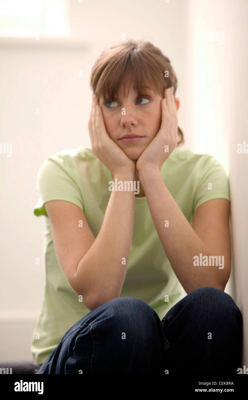 Female hair off face wearing green t shirt and dark blue denim jeans, sitting on top