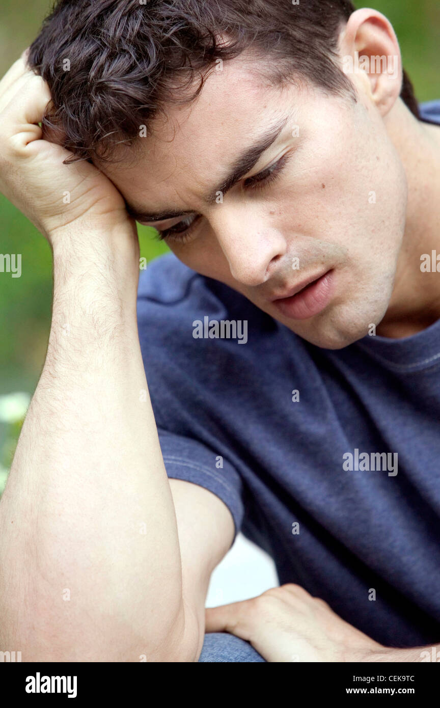 Male With Short Dark Hair Wearing Blue T Shirt Leaning Head