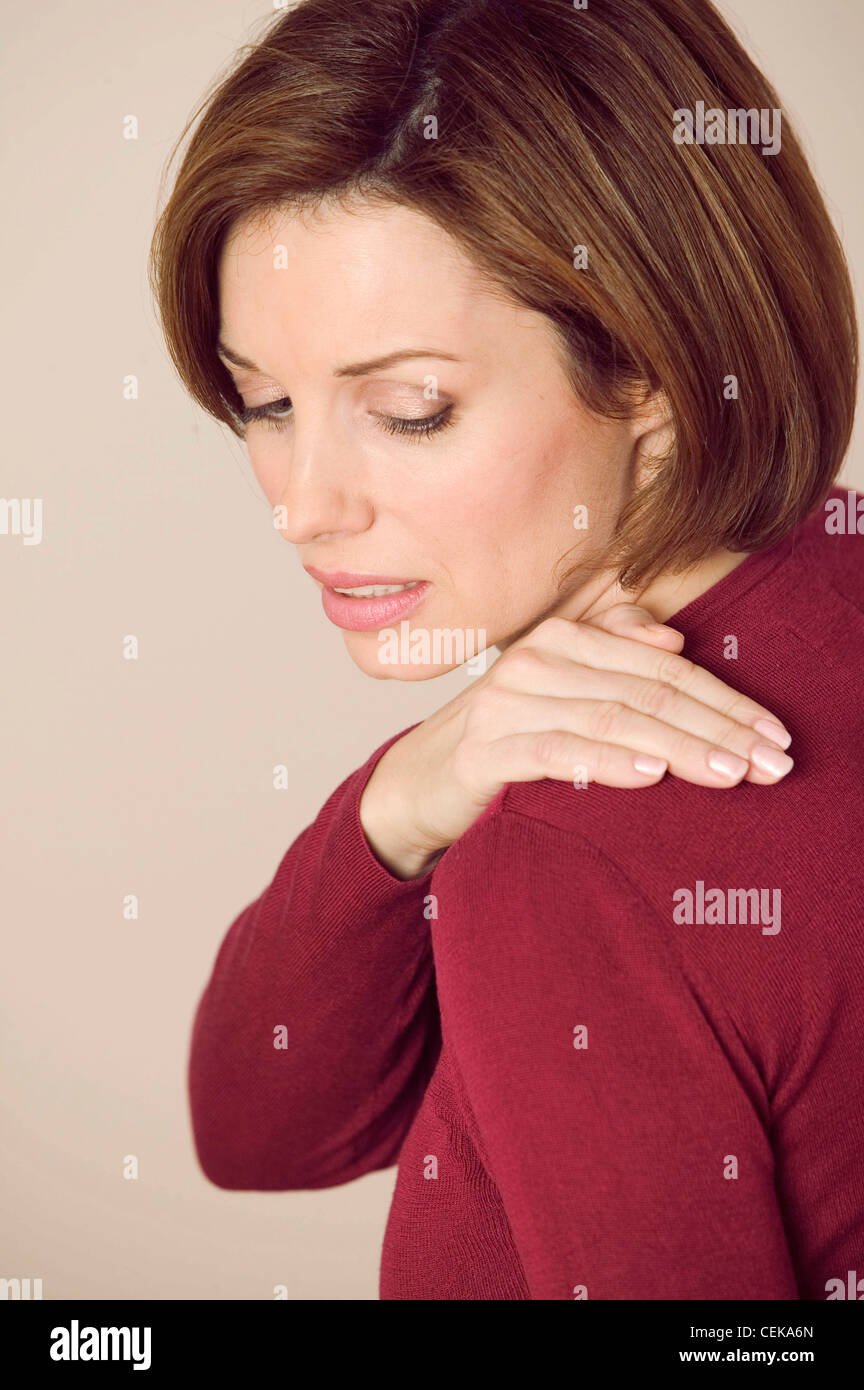 Female with long brunette hair, covering breasts with arms, hands touching  face, unsmiling, looking at camera Stock Photo - Alamy