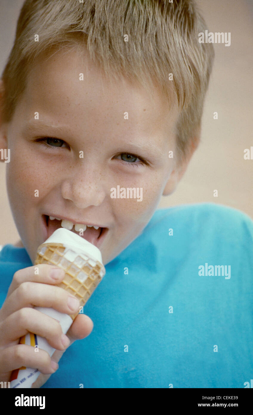 A Boy Wearing A White Shirt Is Eating Ice Cream Stock Photo