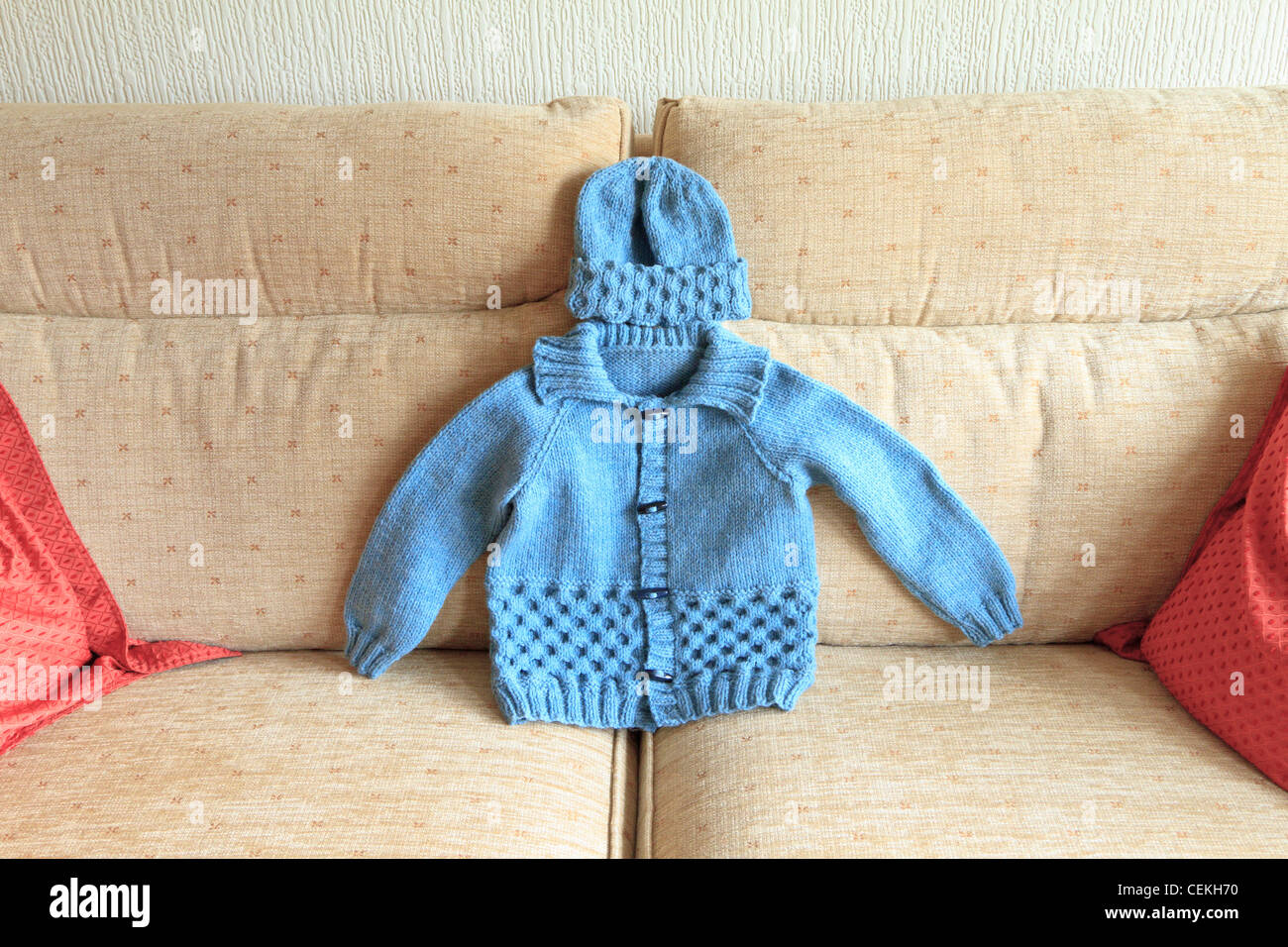 Hand knitted babys coat and hat Stock Photo