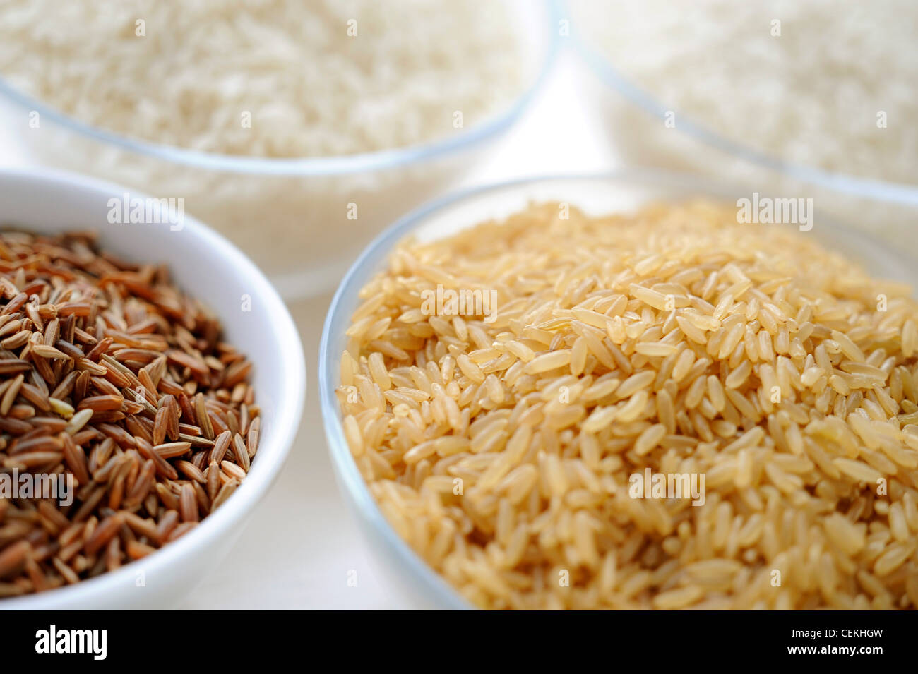 Four bowls of different varieties of rice, with a bowl of red rice and