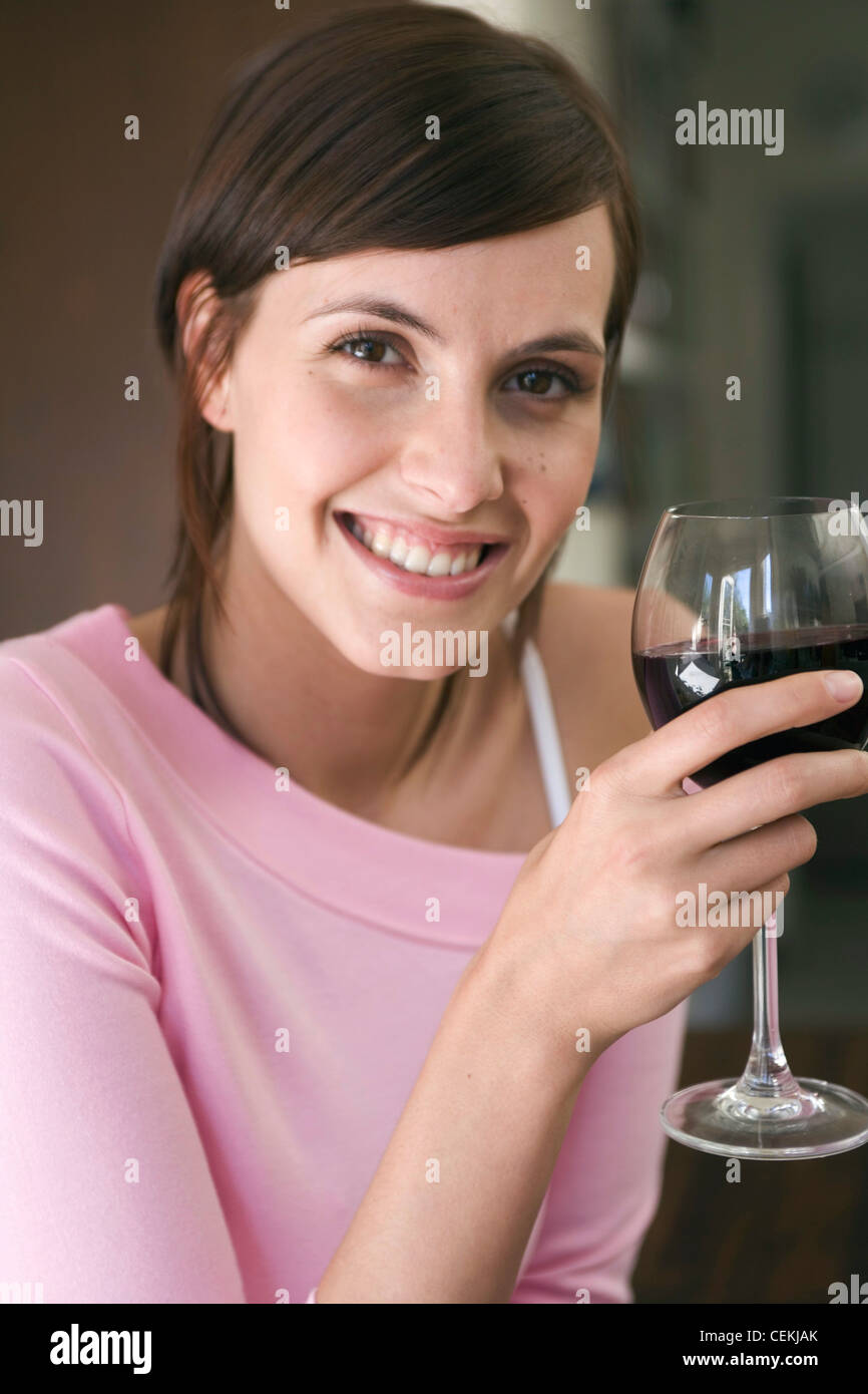 Female, brunette hair pale pink off the shoulder top, drinking glass of ...