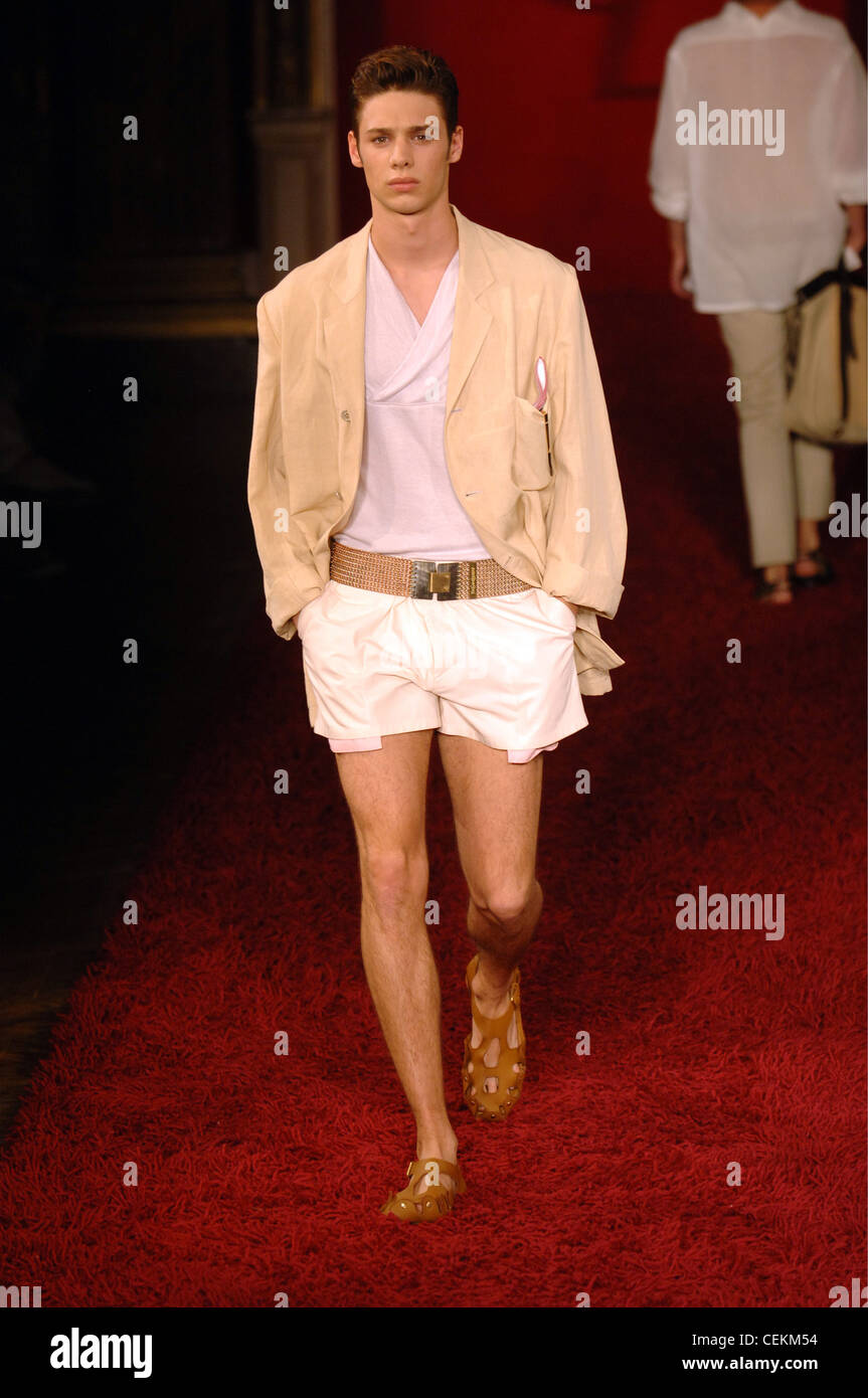 Brunette male model walking on a red carpet runway wearing a tan blaser ...