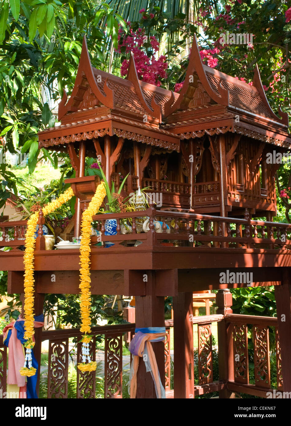 A beautiful teak wood spirit house filled food offeringsthe local spirit inhabiting it to bring good luck and prosperity to Stock Photo