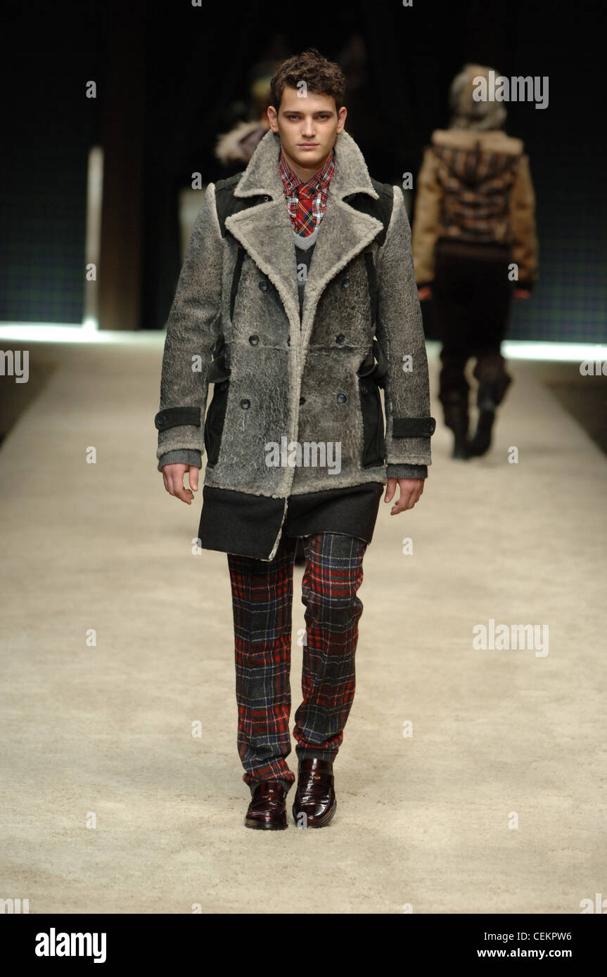 D and G Milan Ready to Wear Autumn Winter  Male wearing grey sheared sheep skin coat and red tartan suit Stock Photo