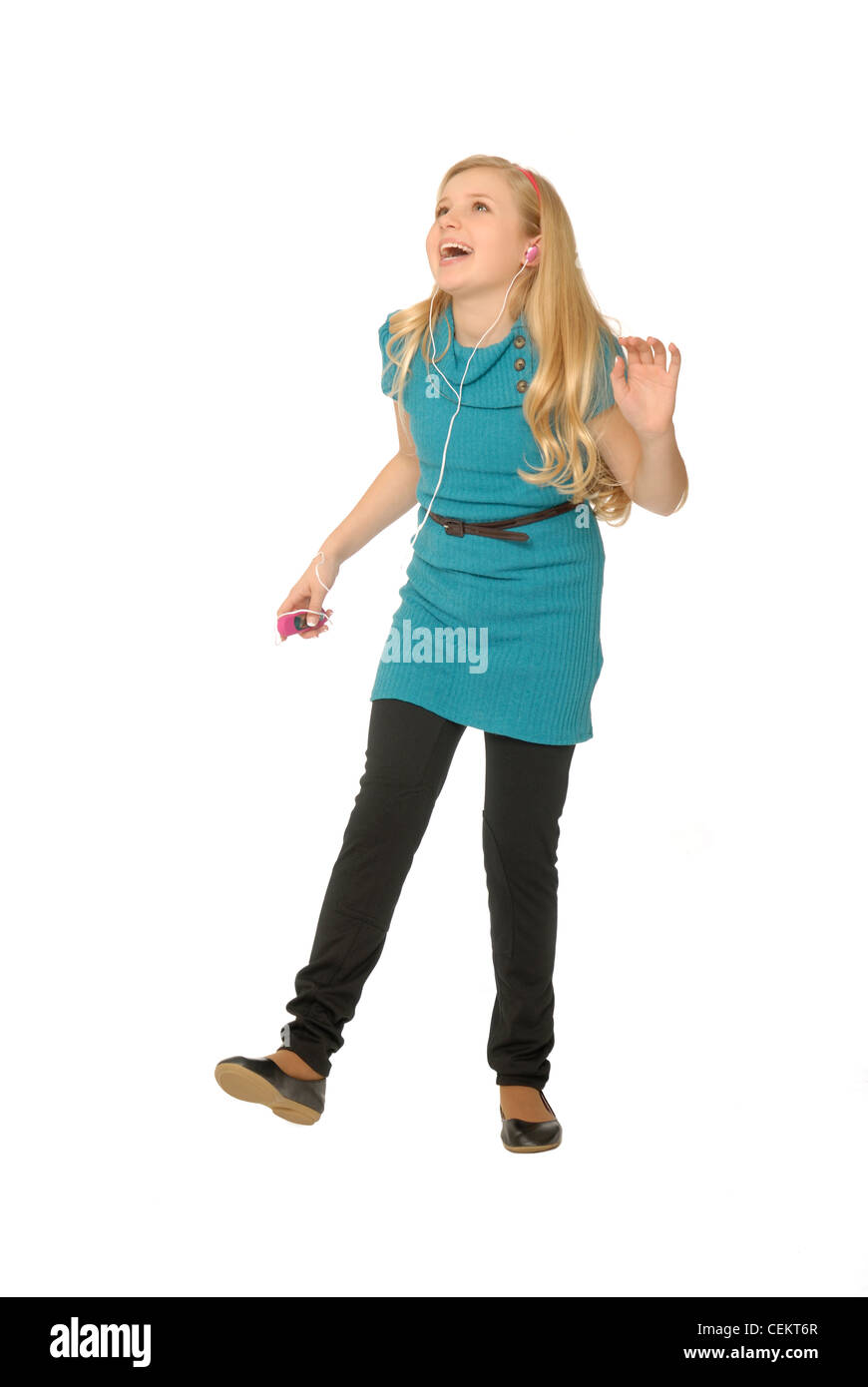Ten year old girl wearing earbuds, listening to mp3 player and dancing. Stock Photo