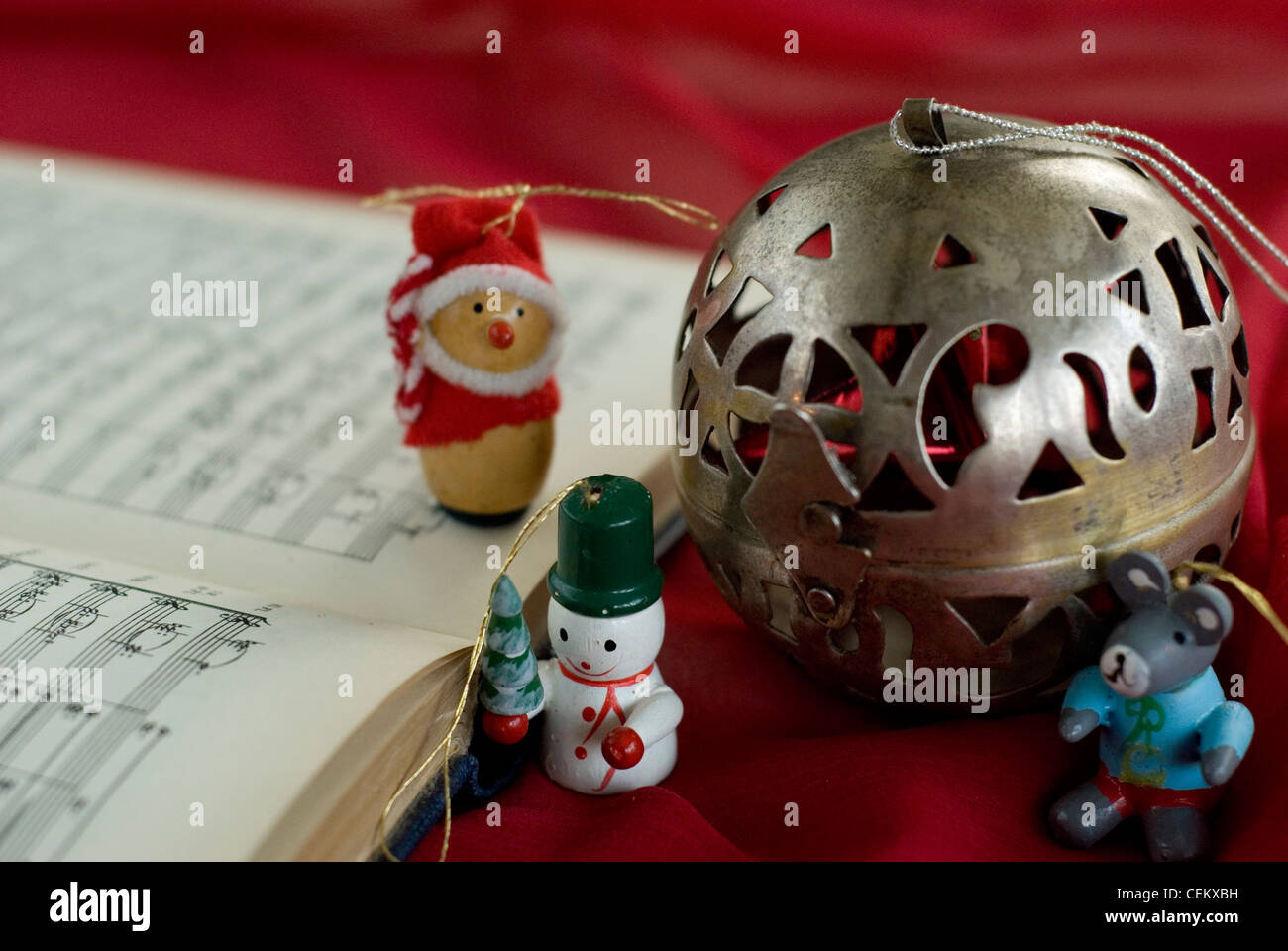 A book of sheet music christmas tree ornaments, of a father christmas, a snowman, a silver ball, and a grey mouse Sophie Stock Photo
