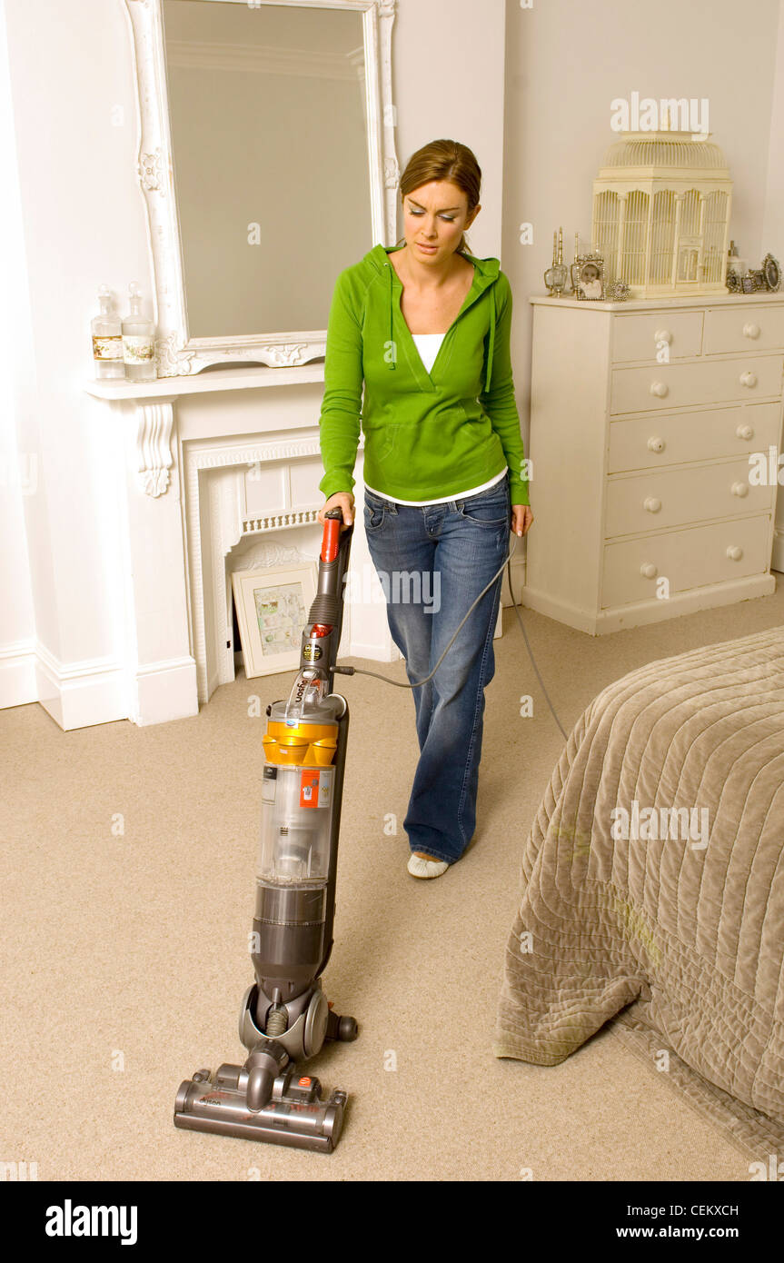 Female vacuuming bedroom carpet Stock Photo - Alamy
