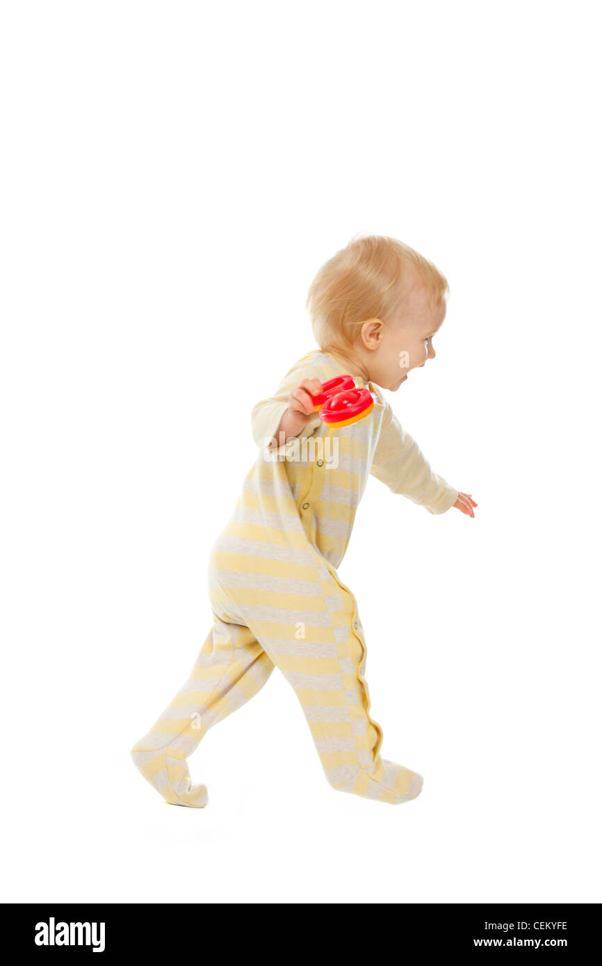 Cheerful baby running with rattle on white background Stock Photo - Alamy