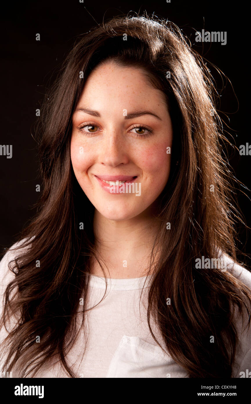 A 20 year old slim attractive healthy young adult woman girl with long rown hair and eyes smiling Stock Photo