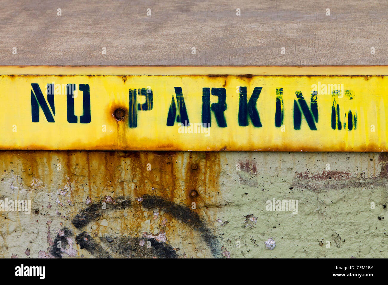 No parking sign painted on a grungy old wall on an abandoned urban building in downtown Denver Colorado USA. Stock Photo