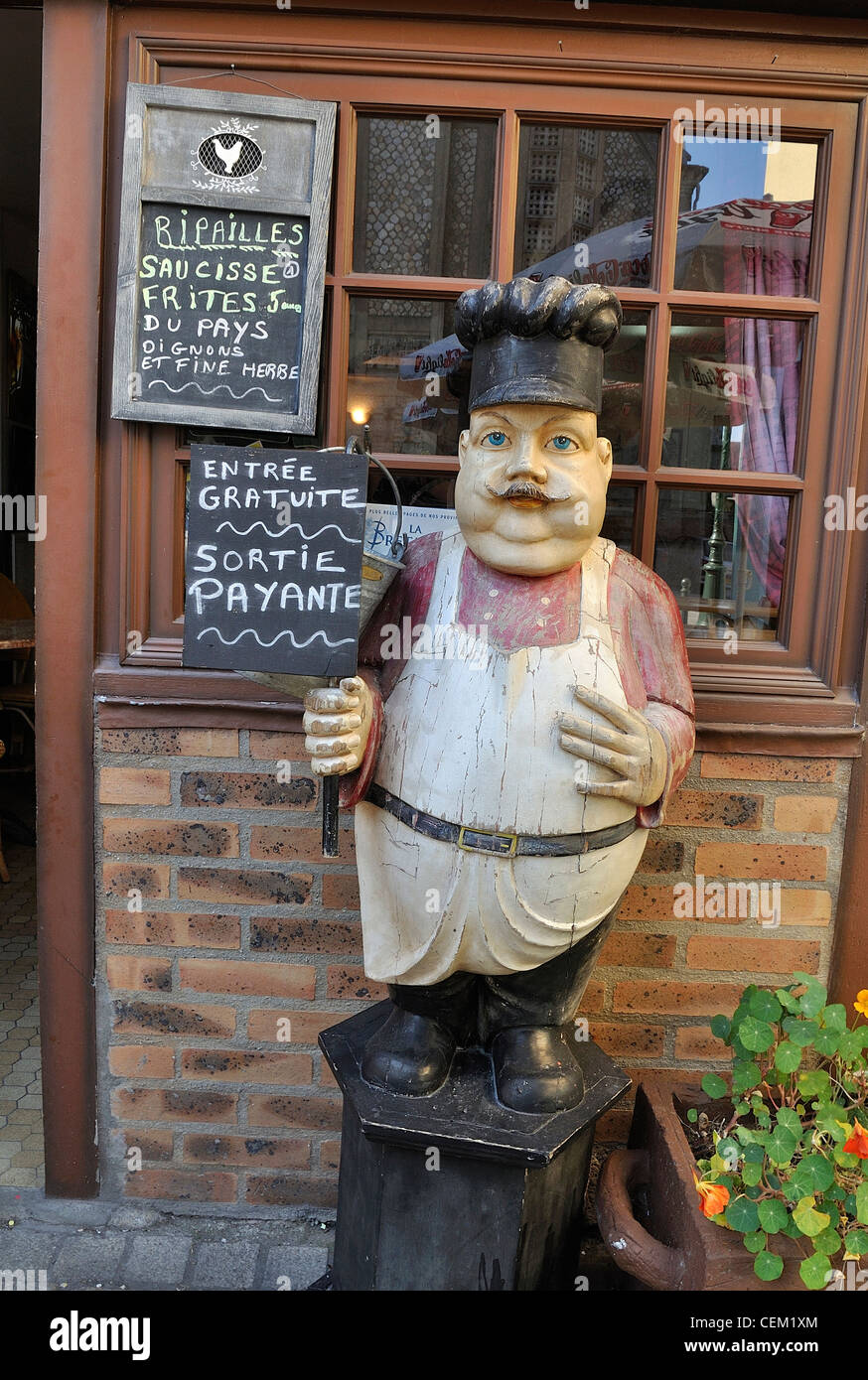 Character carved in wood at the entrance to a bar in the medieval town of Domfront. Stock Photo