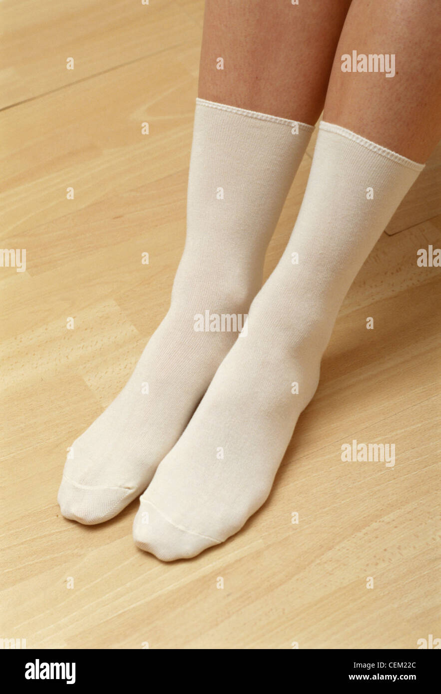 Detail image of female's feet wearing long white socks Stock Photo