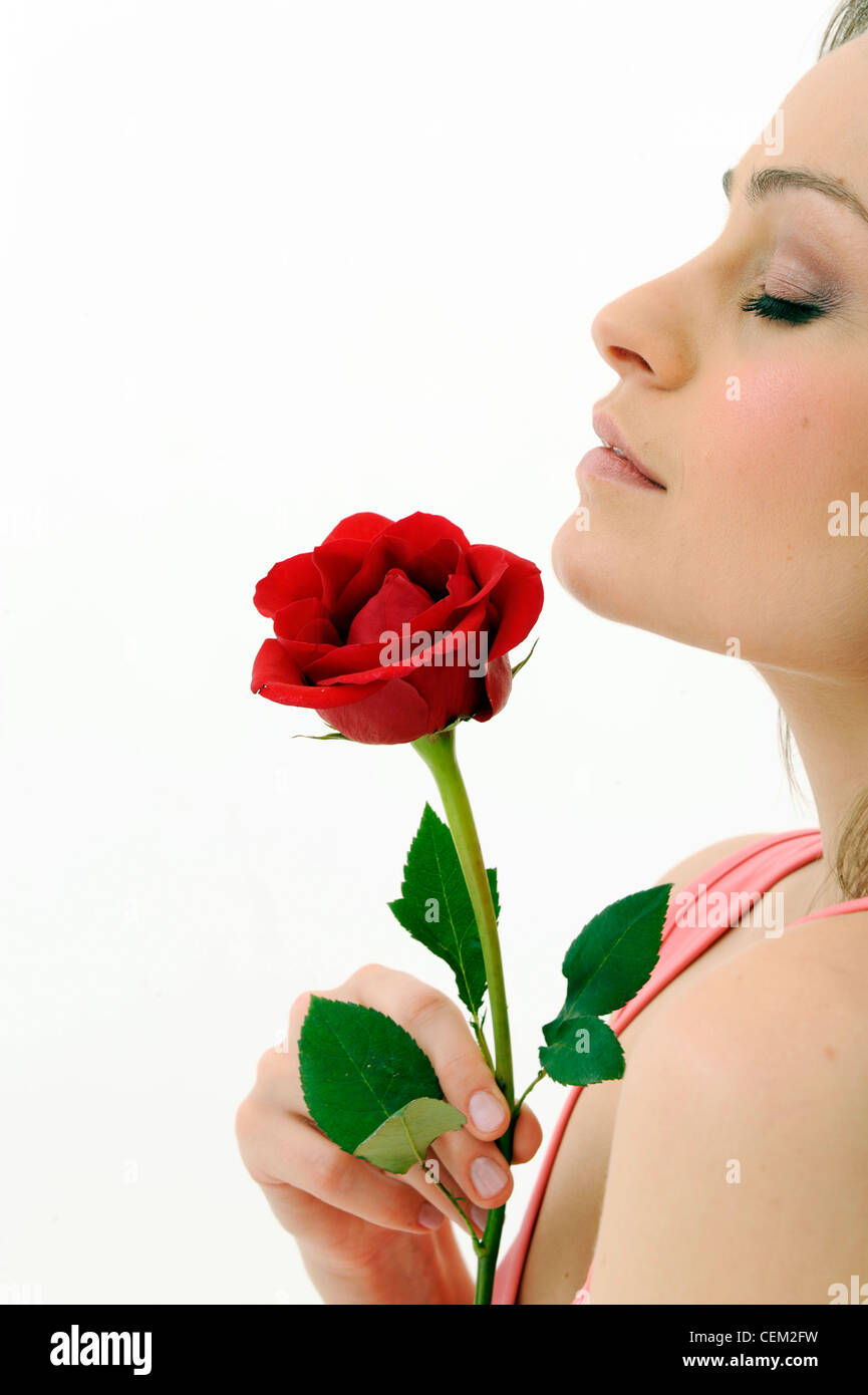 Female Wearing A Pink Vest Holding A Single Red Rose With One Hand