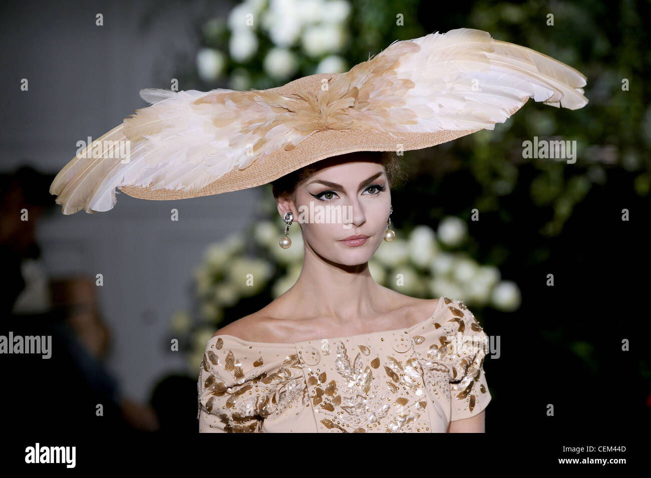 Christian Dior Paris Haute Couture Autumn Winter Model wearing a feathered  straw hat, pearl earrings and embellished off the Stock Photo - Alamy